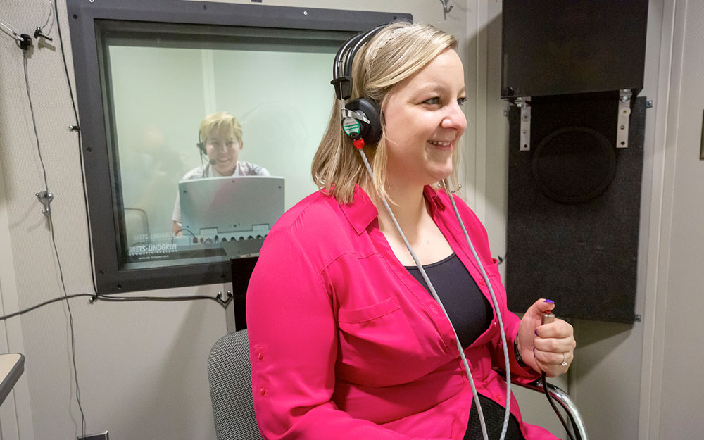 student wearing headphones in a soundbooth