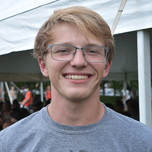 young man with glasses standing outside