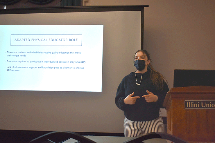 young woman wearing antiviral mask standing at podium