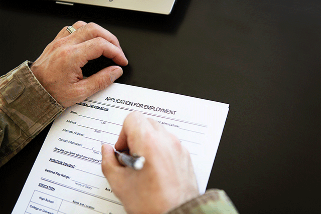 man in camouflage shirt filling out job application