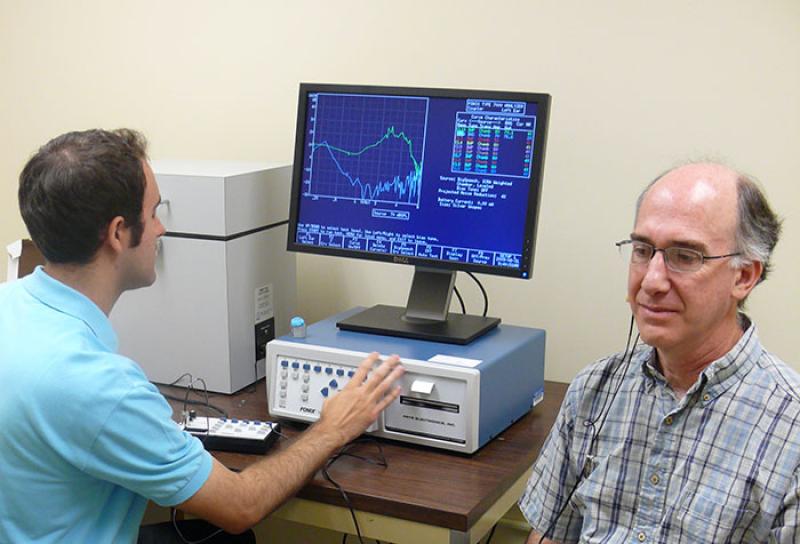 An audiologist checks hearing of a patient