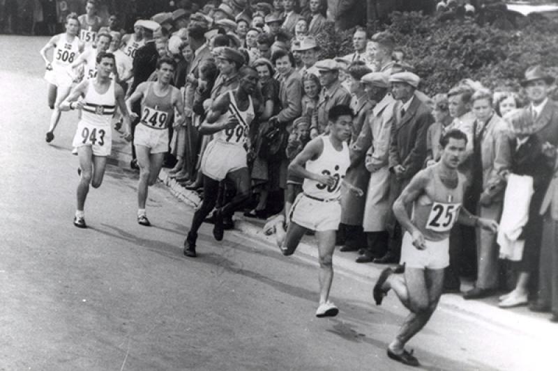 Black and white picture of marathoners running a race in the 1952 Olympic games.