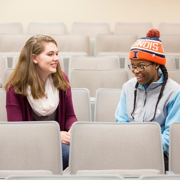 2 students talking in auditorium