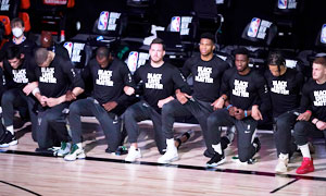 Milwaukee Bucks basketball team kneeling together, wearing t-shirts that say black lives matter