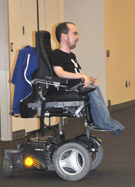 young man seated in power-assisted cart